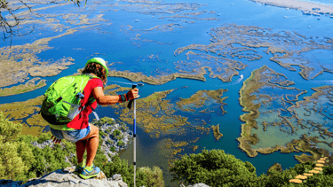a man with a backpack on a hill looking through Iztuzu Beach