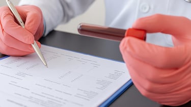 a doctor's hands holding a pen and writing on a paper
