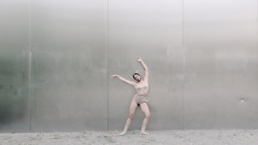  Contemporary dancer with arms extended in minimalist setting – Lingua Materna film still by Tina Bikic