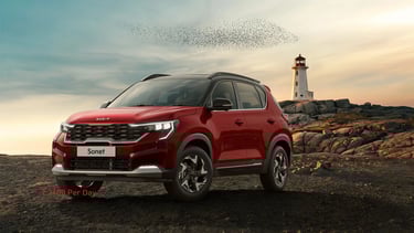 a red suv kia sonet parked on a rocky beach