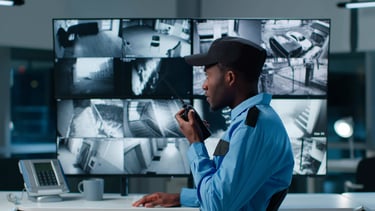 SIA licensed security officer monitoring CCTV screens in commercial control room