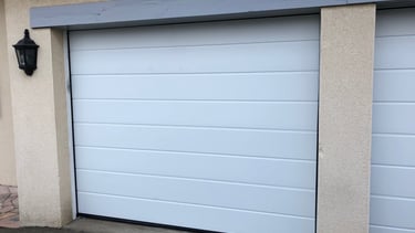 Porte de garage sectionnelle blanche.