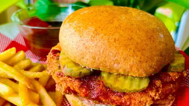 A juicy plant-based patty stacked in a toasted burger bun, layered with pickles, creates a savory