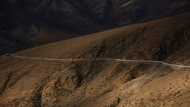 a long line of cars driving down a mountain