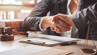 Apretón de manos en oficina legal, asesoramiento en Derecho Laboral.