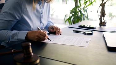 Firma de documento legal con mazo en escritorio