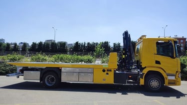 a yellow truck with a crane on it's back