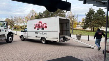 Canada’s Most Wanted Movers unloading at a commercial property in Coquitlam with ramp extended.