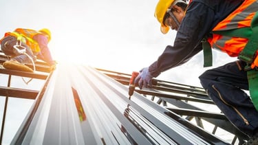 a group of workers working on a metal roof