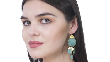 a woman wearing a green handmade patina wash earring