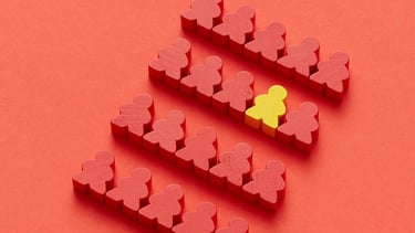 Rode poppetjes met één geel ertussen, symboliseert kwetsbaarheid, verschil en inclusie in beleid.