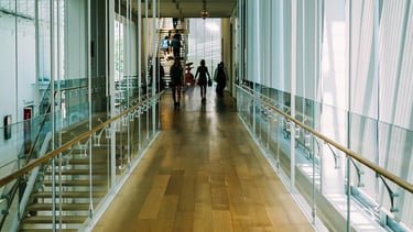 Lichte schoolhal met glas en ruimte, symbool voor openheid en reflectie in digitalisering.