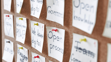 Prikbord vol post-its met woorden, symbool voor teamreflectie en gedeelde inzichten.