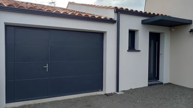 porte de garage noire avec porte intégrée et porte d'entrée mis par l'artisan menuisier en Vendée