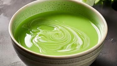 a bowl of green oobleck a flower in the background