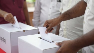 A close-up documentary photo of ballot boxes being sealed by election officials in Karnataka, natural ambient light, 35mm lens.