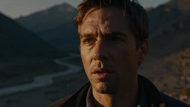 Cinematic film still of an expressive face half-lit in golden chiaroscuro, smoky background of a high-altitude mountain pass, anamorphic lens.