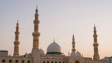 Wide environmental shot of Al-Masjid an-Nabawi in Madinah during dawn, elegant minarets reflecting soft pastel skies, serene negative space, warm editorial photography