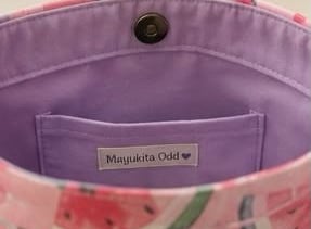 Interior bolso tipo tote con estampado de sandía rosa, forro morado y cierre de botón magnético
