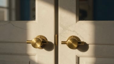 Symmetrical close-up of premium warm brass fixtures embedded in polished white Calacatta marble, soft golden-hour window light casting long shadows, shallow depth of field, 35mm
