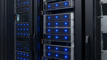 A photograph of a modern server rack with steel blue status lights in a dark room. Represents the technical rigor of game development. North American / International data center.