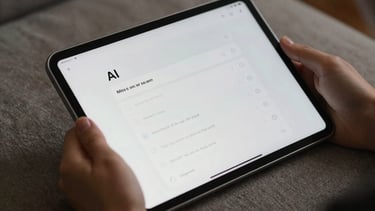 Close-up of a digital tablet showing a minimalist accordion UI with AI tips, held in a hand over a high-end textured fabric surface.