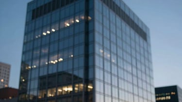 Blurred background of a modern glass office building at twilight. Sky blue and dark blue grey tones, North American / International urban vibe.
