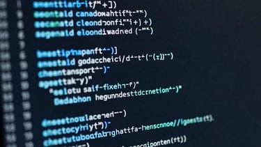 Details of lines of clean code on a dark screen with syntax highlighting in shades of blue and cyan, illustrating expertise and precision.