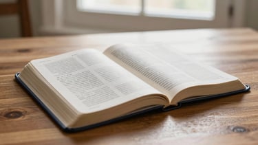 Warm editorial photography of an open Bible with handwritten notes on a wooden table, soft natural window light, deep navy and gold tones, shallow depth of field, 35mm