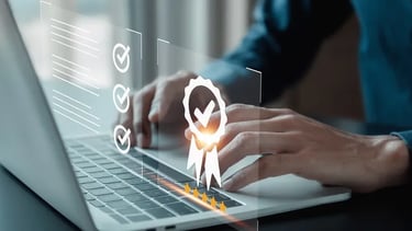 Professional person using a laptop with digital icons for quality assurance and certification.