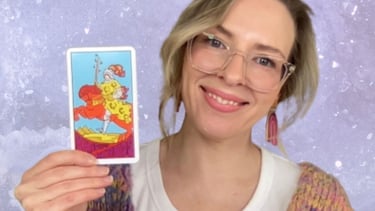 Natalie Grace, Tarot Teacher, holding the Knight of Wands tarot card.