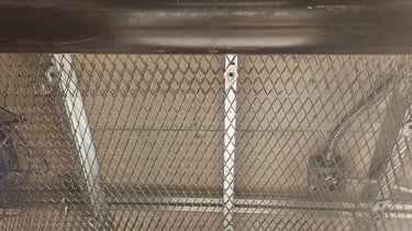 Secure ceiling installation using heavy-duty wire mesh above a suspended ceiling to prevent access t