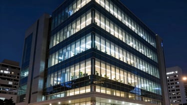 A professional and sleek photography of a South American corporate tech headquarters at night. The building features a modern glass architecture with glowing blue and white internal lights. The atmosphere is sophisticated and innovative, set in a clean urban environment in Brazil, reflecting high-standard IT infrastructure and elegance.