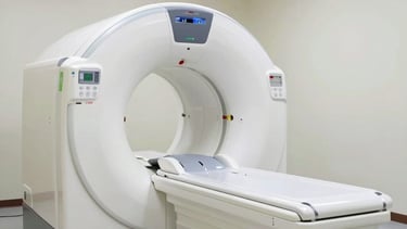 Technician operating a CT scan machine with patient