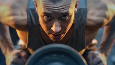 a man doing a push up barbell in a gym