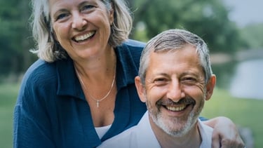 A happy senior couple smiling outdoors, representing healthy aging and retirement lifestyle.