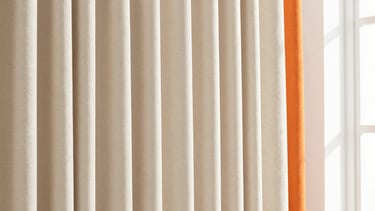 Close-up of perfectly pleated beige curtain fabric, natural sunlight creating soft shadows, highlighting texture and neat stitching, bright interior photography.