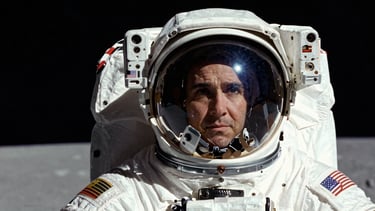 Low-angle heroic portrait of an Artemis III astronaut in a white spacesuit, harsh direct sunlight, visor reflecting the lunar lander