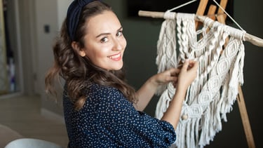 Mujer creando macramé con hilo blanco