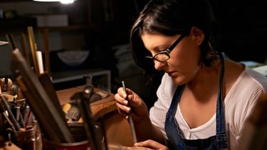 Joyera artesanal creando joyería a mano en estudio con herramientas especializadas