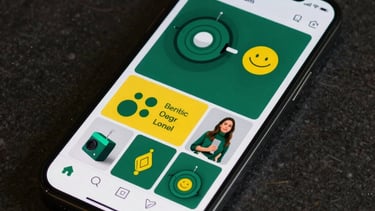 A well-composed shot of a modern smartphone displaying a stylish Instagram feed with cohesive emerald green and yellow brand colors.