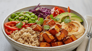 Bol Buddha végétalien composé de patates douces rôties, riz complet, houmous, avocat et edamames.