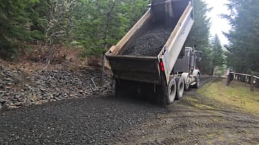 dump truck spreading gravel on driveway