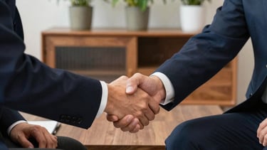 A professional shaking hands with a client in a modern office setting
