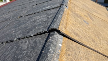 Tight macro detail of waterproof sealing application on a damaged roof valley, precise hand work, natural daylight.