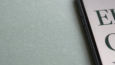 Macro shot of textured paper stocks and digital screen displaying matching typography, soft diffused daylight, muted slate and sage tones