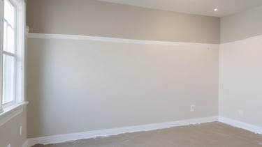 A professional handyman carefully patching drywall inside a bright living room