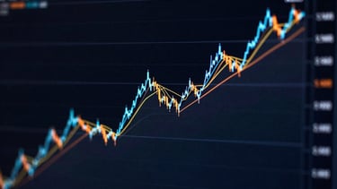Close-up of a multi-line comparison chart on a dark monitor, three distinct lines in electric blue, orange, and cyan representing different crypto assets, dark background with subtle glow along each line, high contrast, screen-lit environment, no text