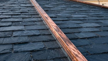 Professional photography of a renovated luxury roof in a French city. Close-up on elegant slate tiles and copper metal work. Soft morning sunlight. Colors include dark slate blue, bronze brown, and pale blue. European artisanal quality.