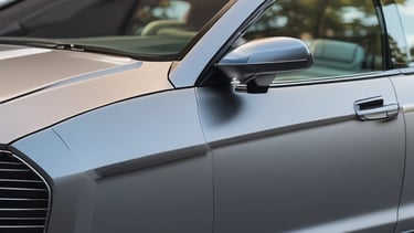 A shiny black car with freshly tinted windows parked under bright sunlight